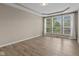 Bright bedroom with tray ceiling, hardwood floors, and a large window at 10346 Strongbow Rd, Fishers, IN 46040
