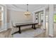 Elegant dining room with wainscoting, columns, tray ceiling, and chandelier over a wood table with seating at 10346 Strongbow Rd, Fishers, IN 46040