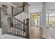 Grand foyer with staircase, hardwood floors, decorative columns, and transom window over front door at 10346 Strongbow Rd, Fishers, IN 46040