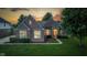 Beautifully lit brick home at sunset, showcasing its architectural details and lush green lawn at 10346 Strongbow Rd, Fishers, IN 46040