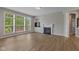 Cozy living room with built-in shelving, a fireplace, large windows, and light hardwood flooring at 10346 Strongbow Rd, Fishers, IN 46040