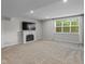 Spacious living room with a fireplace, large windows, and neutral carpeting at 10346 Strongbow Rd, Fishers, IN 46040