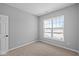 Bedroom with neutral carpet and grey walls, features a bright window and a white door at 16946 Cattle Hollow Ln, Noblesville, IN 46060