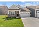 Charming home showcasing stone accents, a manicured lawn, and a spacious two-car garage at 16946 Cattle Hollow Ln, Noblesville, IN 46060