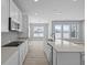 Modern kitchen features white cabinets, quartz countertops, stainless steel appliances, and large center island at 16946 Cattle Hollow Ln, Noblesville, IN 46060