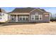 Grey home exterior featuring a covered patio, large windows, and a freshly seeded lawn at 19566 Wood Farm Pl, Westfield, IN 46074