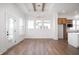 Bright dining area with wood floors, tray ceiling, modern lighting, and a view of the lake through three large windows at 19566 Wood Farm Pl, Westfield, IN 46074