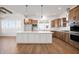 Open kitchen featuring a large island, stainless appliances, tile backsplash, modern lighting, and wood floors at 19566 Wood Farm Pl, Westfield, IN 46074