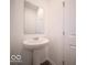 Powder room featuring a pedestal sink, large mirror, and white walls at 248 Highland Ave, Danville, IN 46122