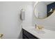 Small bathroom with gold accents and a round mirror at 2746 Cadogan Dr, Greenwood, IN 46143