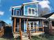 Stunning two-story blue home with a modern design, wooden porch, and landscaped lawn at 3271 Winthrop Ave, Indianapolis, IN 46205