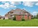 A spacious backyard with a stone fence and mature trees offer privacy and charm at 1038 White Oak Dr, Plainfield, IN 46168