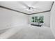 Bright bedroom with large window, ceiling fan, neutral carpet, and view of backyard greenery at 1038 White Oak Dr, Plainfield, IN 46168