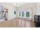 Bright dining area featuring laminate flooring, a modern chandelier, and a view into a nearby living area at 1038 White Oak Dr, Plainfield, IN 46168