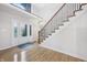 Bright foyer featuring hardwood floors, a striking staircase, and a modern entry door at 1038 White Oak Dr, Plainfield, IN 46168