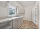 Bright laundry room featuring a window, upper cabinets, and spacious countertop at 1038 White Oak Dr, Plainfield, IN 46168