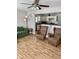 Comfortable living room with hardwood floors, green sofa, and ceiling fan next to kitchen at 2104 N Ball Ave, Muncie, IN 47304