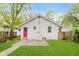 The home's backyard featuring fresh lawn, concrete patio and a bright red door at 625 N Grant Ave, Indianapolis, IN 46201