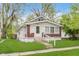 Charming home with white siding, brick accents, and a well-maintained front lawn at 625 N Grant Ave, Indianapolis, IN 46201