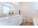 Bathroom with double sinks, white cabinetry, a large mirror, and modern fixtures plus a stand alone bathtub at 14446 Chapelwood Ln, Fishers, IN 46037