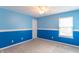 Bright bedroom with two-tone blue walls, a ceiling fan, a window with blinds, and plush carpeting at 14446 Chapelwood Ln, Fishers, IN 46037