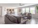 Open-concept living room and dining area featuring modern gray couches and lots of natural light at 14446 Chapelwood Ln, Fishers, IN 46037