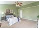 Bedroom with green walls, plush carpet, and a comfortable bed with neutral and blue accents at 14446 Chapelwood Ln, Fishers, IN 46037