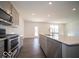 Open kitchen features stainless appliances, island with sink, and gray cabinetry with backyard views at 1573 Hanover St, Danville, IN 46122