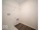 Compact laundry room with modern tile flooring, utility connections, and wire shelving at 1573 Hanover St, Danville, IN 46122