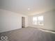 Neutral living room showcasing carpeted flooring and a window that offers plenty of natural light at 1573 Hanover St, Danville, IN 46122