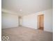 Spacious bedroom with neutral carpeting and bright natural light from an open doorway to the bathroom at 1579 Hanover St, Danville, IN 46122