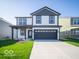 Two-story home featuring white siding, dark gray trim, a front porch, and an attached two-car garage at 1579 Hanover St, Danville, IN 46122