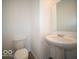 Well-lit half bathroom featuring a pedestal sink, toilet, and a large mirror at 1579 Hanover St, Danville, IN 46122