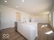 Modern island in kitchen with stainless steel dishwasher and view to living area at 1579 Hanover St, Danville, IN 46122