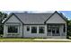 Rear view of a modern single-story home featuring a patio and a manicured lawn at 16298 Grand Cypress Dr, Noblesville, IN 46060