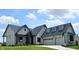 Beautiful new construction home featuring a three car garage, stone exterior and a manicured lawn at 16298 Grand Cypress Dr, Noblesville, IN 46060