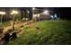 Large, well-lit backyard with a manicured lawn, stone benches, and a quaint brick accent near the house at 2227 Hidden Orchard Ct, Indianapolis, IN 46228