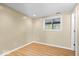 Cozy bedroom featuring laminate flooring, neutral colors, and a large window for natural light at 2227 Hidden Orchard Ct, Indianapolis, IN 46228