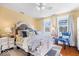 Bright bedroom features hardwood floors, a plush bed, and a bedside table lamp at 2227 Hidden Orchard Ct, Indianapolis, IN 46228