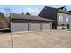 Three-car garage with grey doors and ample parking space in front of the building at 2227 Hidden Orchard Ct, Indianapolis, IN 46228
