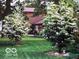 Beautifully landscaped front yard featuring a well-manicured lawn and flowering trees at 1024 N Michigan St, Greenfield, IN 46140