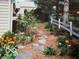 Beautiful garden area with flowers and stone pathway to fence and exterior building at 1024 N Michigan St, Greenfield, IN 46140