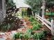 Landscaped garden with flowers, stone path, and a white fence surrounding the perimeter at 1024 N Michigan St, Greenfield, IN 46140