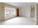 Spacious living room with a large window, wood door, carpet, and a hallway at 1024 N Michigan St, Greenfield, IN 46140