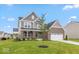 Attractive two story home featuring brick accents, a covered porch, an attached garage, and manicured lawn at 15468 Streamwood Dr, Fishers, IN 46037