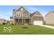 Charming two-story home with a well-manicured lawn, brick and siding exterior and an attached two-car garage at 15468 Streamwood Dr, Fishers, IN 46037