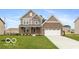 Charming two-story home with a well-manicured lawn, brick and siding exterior and an attached two-car garage at 15468 Streamwood Dr, Fishers, IN 46037