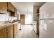 A kitchen with wood cabinets, tile flooring, a dishwasher and standard appliances in a functional layout at 8016 Minlo Dr, Indianapolis, IN 46227