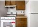 Close up of white oven and wood cabinets inside kitchen, with white appliances and tile floor at 8016 Minlo Dr, Indianapolis, IN 46227