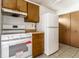 This is a well-lit kitchen, featuring a white range, refrigerator and wood cabinets at 8016 Minlo Dr, Indianapolis, IN 46227